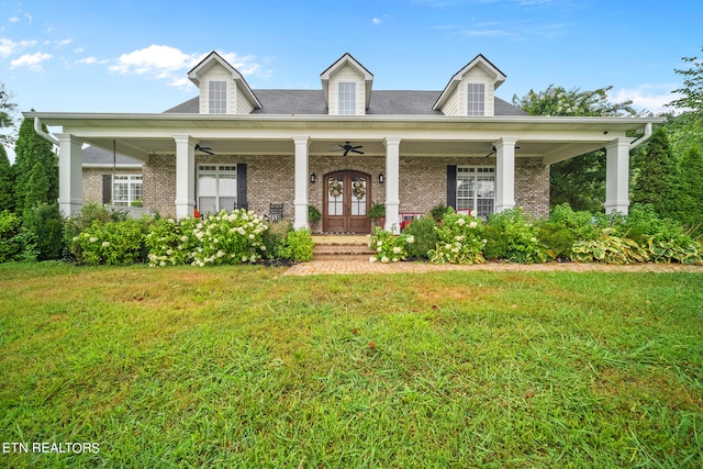 cape cod house featuring covered porch and a front yard