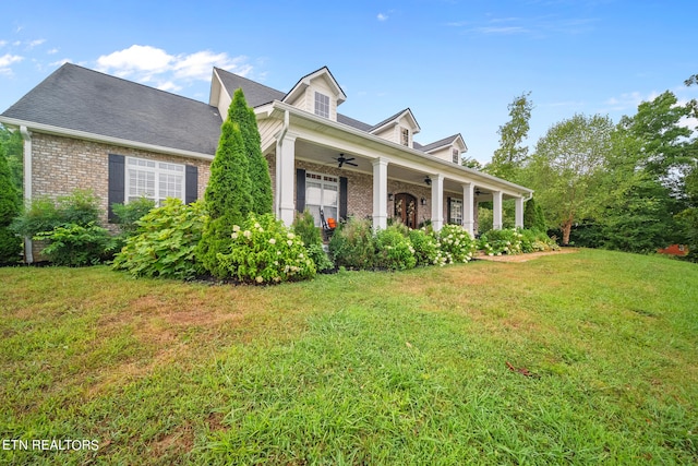 cape cod house featuring ceiling fan and a front lawn