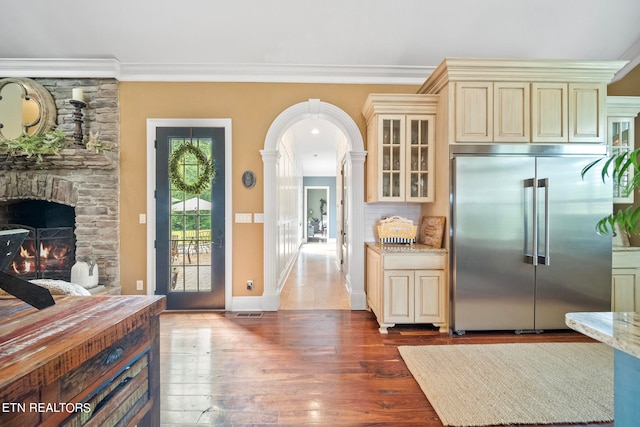 kitchen featuring a fireplace, cream cabinets, built in fridge, and ornamental molding