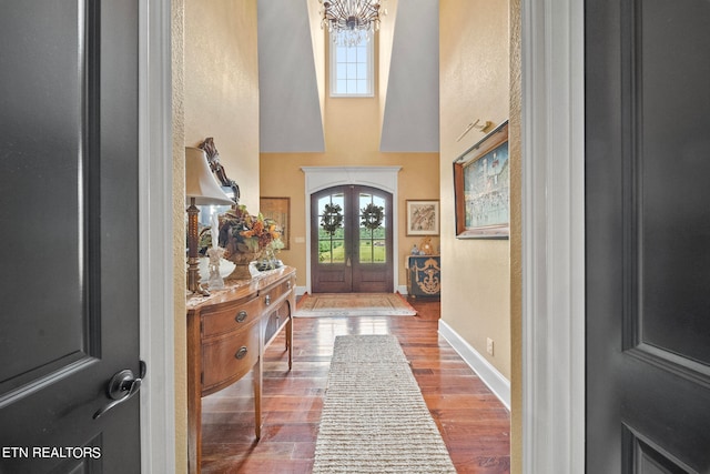 entrance foyer featuring a notable chandelier, french doors, and hardwood / wood-style floors