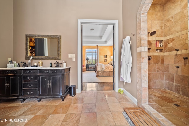 bathroom featuring dual vanity, tile patterned flooring, a tile shower, and a raised ceiling