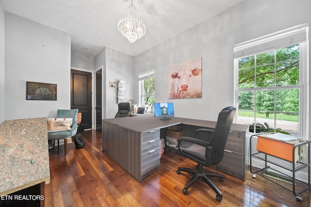 home office featuring dark wood-type flooring and a notable chandelier