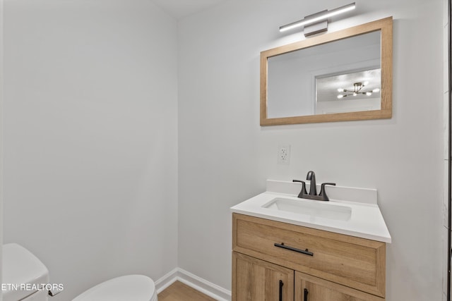 bathroom with wood-type flooring, toilet, and vanity