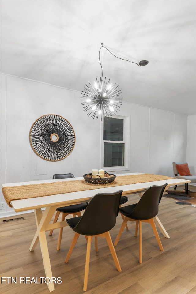 dining room featuring an inviting chandelier and light wood-type flooring