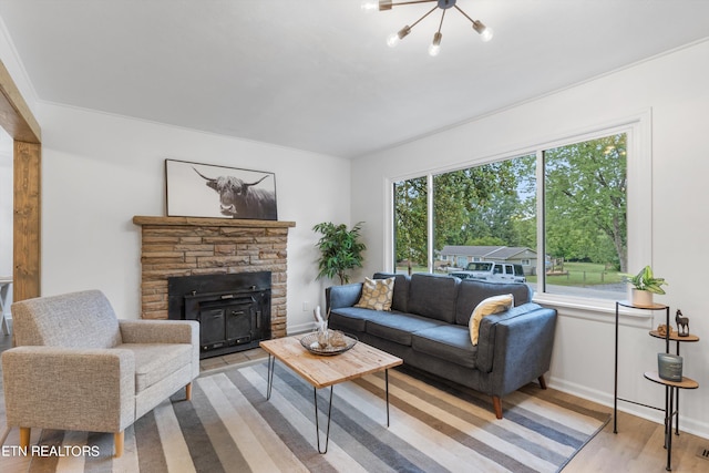 living room featuring a fireplace, light hardwood / wood-style floors, and ornamental molding