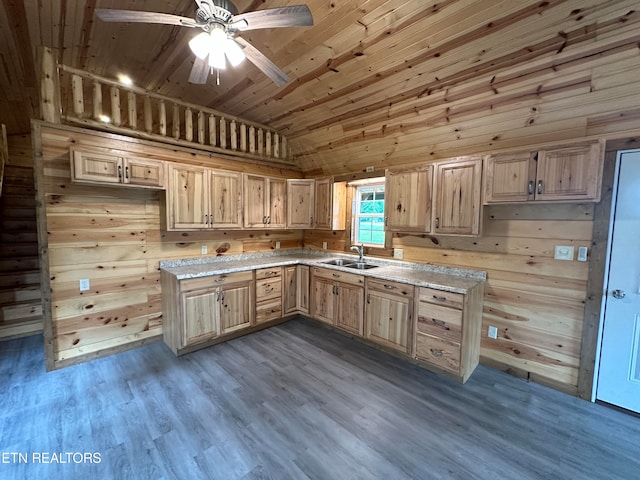 kitchen with sink, light brown cabinets, lofted ceiling, wood walls, and hardwood / wood-style flooring