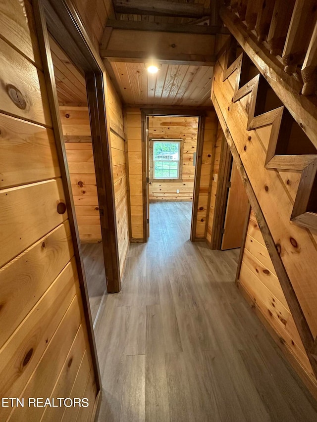 hall featuring wood walls, light hardwood / wood-style flooring, and wood ceiling