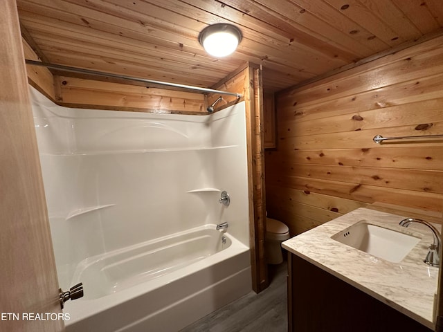 full bathroom with vanity, shower / bathing tub combination, toilet, and wood walls