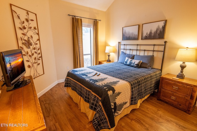 bedroom featuring hardwood / wood-style flooring and vaulted ceiling