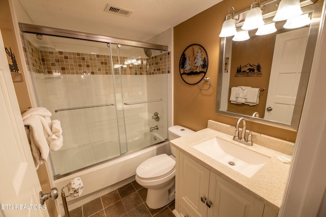 full bathroom featuring tile patterned flooring, enclosed tub / shower combo, a textured ceiling, toilet, and vanity