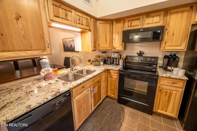 kitchen featuring tile patterned flooring, black appliances, light stone countertops, and sink