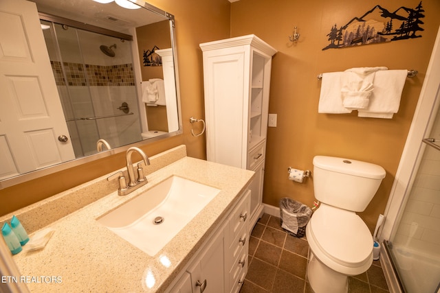 bathroom featuring vanity, walk in shower, tile patterned flooring, and toilet