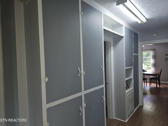 corridor with dark hardwood / wood-style floors and a textured ceiling