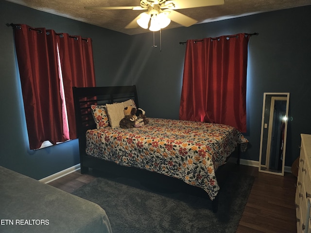 bedroom featuring ceiling fan, dark wood-type flooring, and a textured ceiling