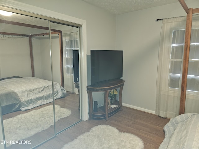 bedroom featuring hardwood / wood-style floors, a closet, and a textured ceiling