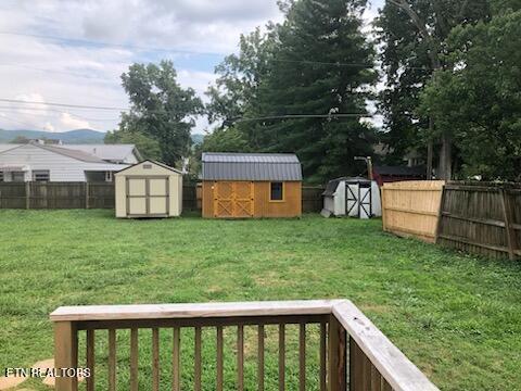 view of yard featuring a storage shed and a wooden deck