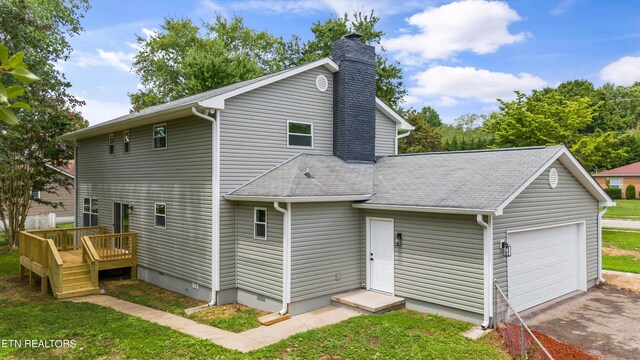 rear view of house with a garage and a deck