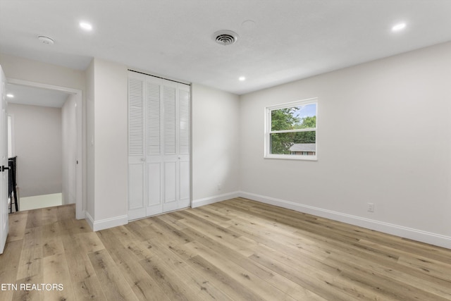 unfurnished bedroom featuring a closet and light wood-type flooring