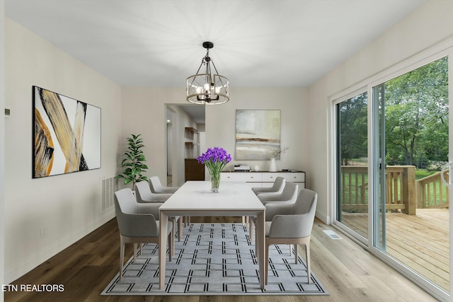 dining room with wood-type flooring and a chandelier