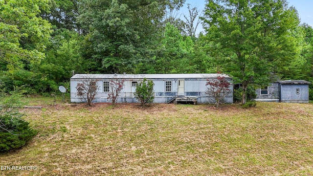 view of front of house with a shed and a front lawn