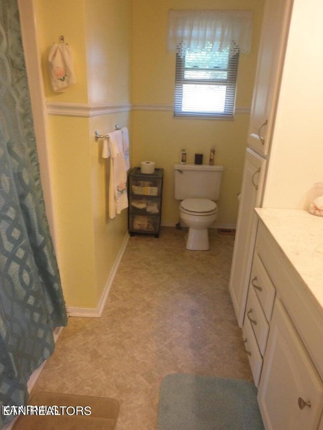 bathroom with toilet, tile patterned floors, and vanity