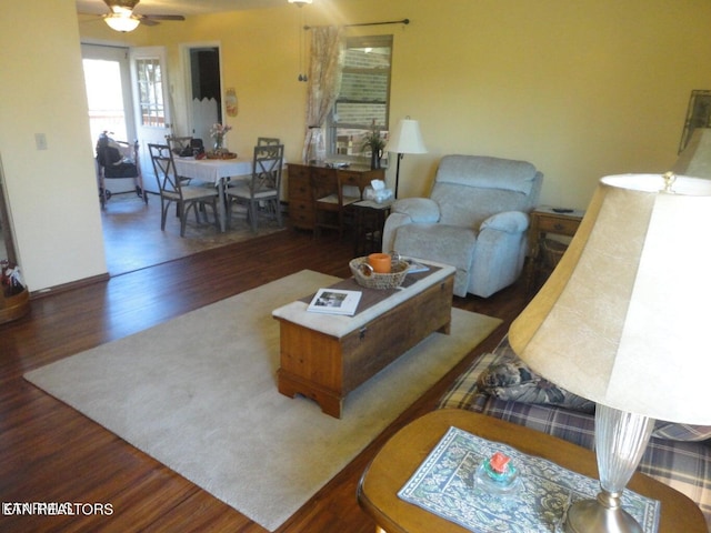 living room featuring ceiling fan and dark hardwood / wood-style flooring