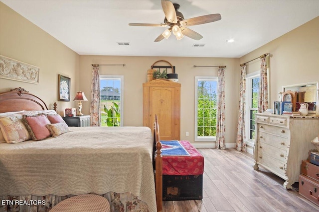 bedroom featuring ceiling fan, wood-type flooring, and multiple windows