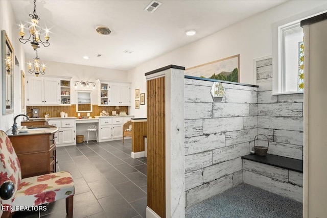 bathroom featuring sink, a chandelier, tile patterned flooring, and decorative backsplash