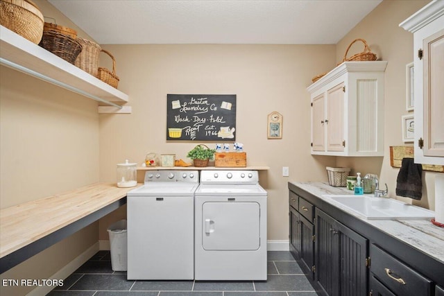 laundry room with cabinets, sink, washing machine and clothes dryer, and dark tile patterned floors