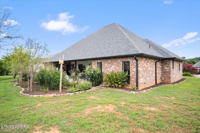 view of side of property with a lawn