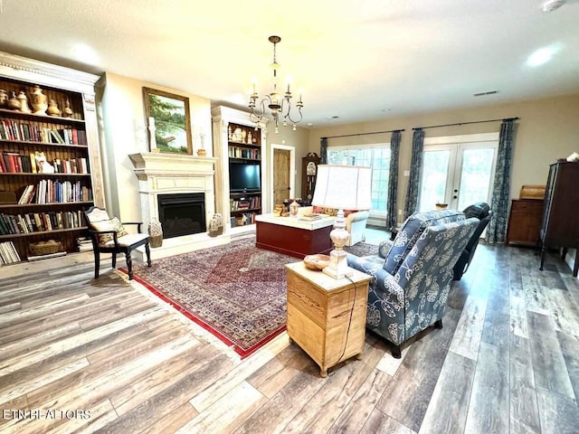 living room featuring a notable chandelier, hardwood / wood-style flooring, and french doors