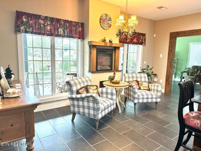 living area featuring a notable chandelier and dark tile patterned floors