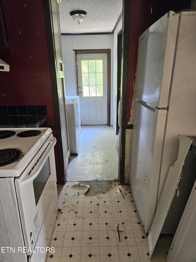 kitchen with white appliances, washer / clothes dryer, light floors, and a textured ceiling