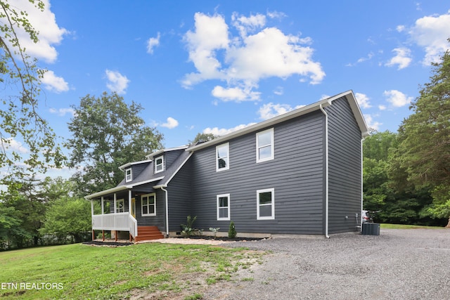 back of house with a porch, a yard, and central AC unit