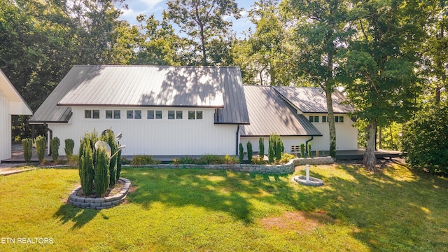 view of front of home featuring a standing seam roof, a front yard, and metal roof