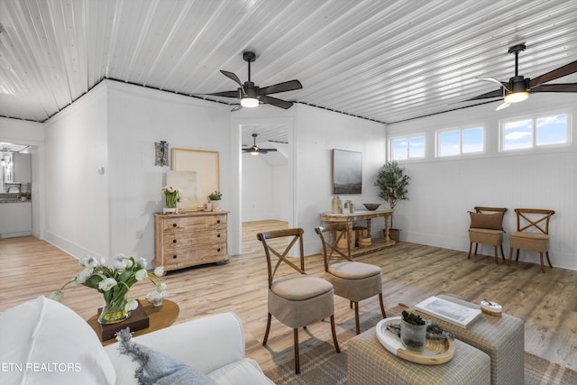 living area with wood finished floors and a ceiling fan