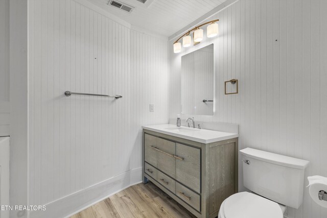 bathroom featuring hardwood / wood-style flooring, vanity, and toilet