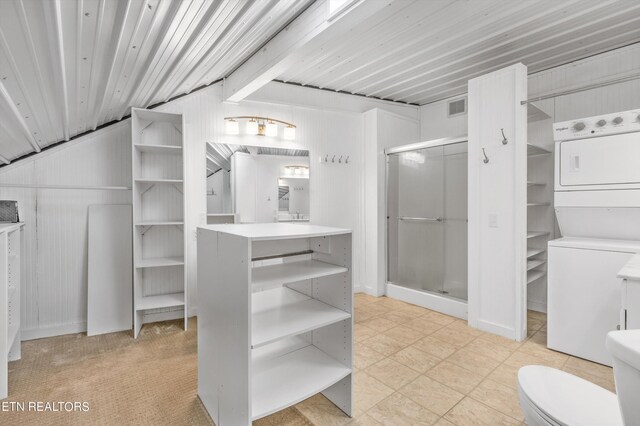 bathroom with lofted ceiling, stacked washer / drying machine, toilet, an enclosed shower, and vanity