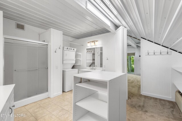 bathroom featuring walk in shower, stacked washer / drying machine, and sink