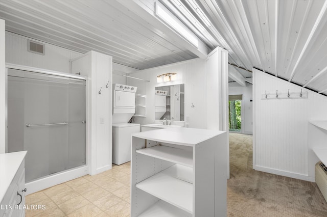 walk in closet with a sink, visible vents, and stacked washer / dryer