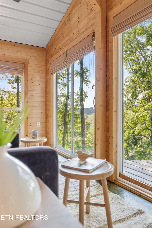 dining room with wooden walls and lofted ceiling