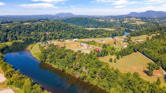 birds eye view of property with a wooded view and a water and mountain view