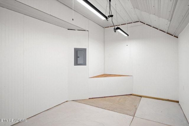 interior space with lofted ceiling, concrete flooring, and electric panel