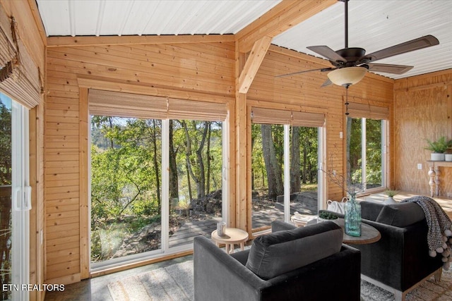 sunroom with plenty of natural light, a ceiling fan, and vaulted ceiling