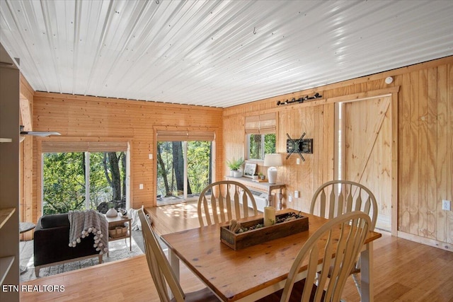 dining room featuring hardwood / wood-style flooring, wooden walls, and wooden ceiling