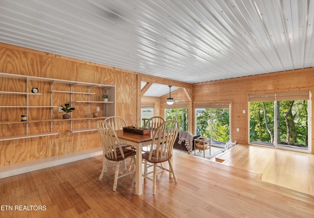 dining area with wood-type flooring and wood walls