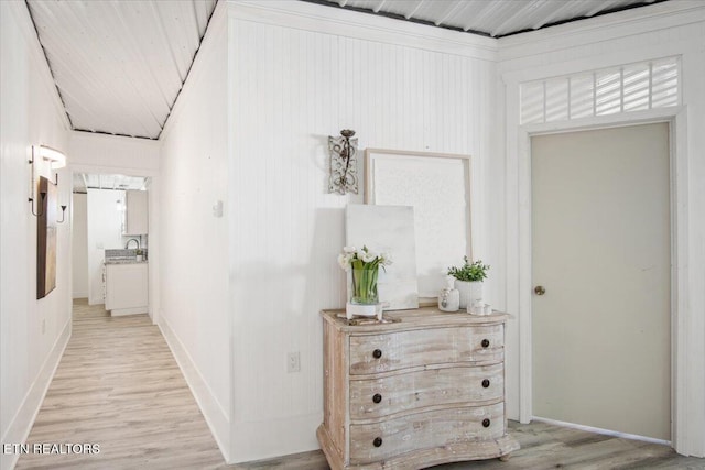 corridor with light wood-style flooring and baseboards