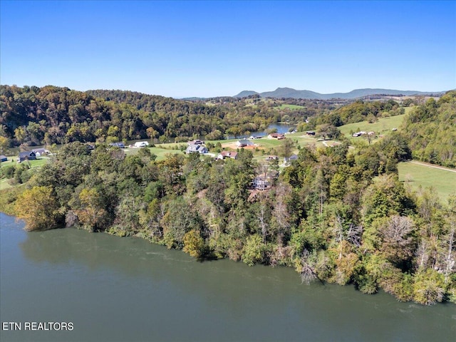 drone / aerial view featuring a forest view and a water and mountain view