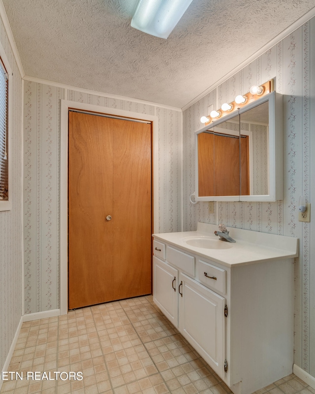 bathroom featuring tile patterned floors, ornamental molding, vanity, and a textured ceiling