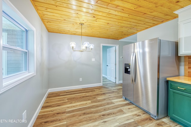 kitchen featuring butcher block counters, a healthy amount of sunlight, green cabinetry, stainless steel fridge with ice dispenser, and decorative light fixtures